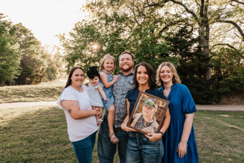 Family smiling together in a park.